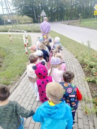 Dzieci idą za nauczycielem i oglądają znaki.