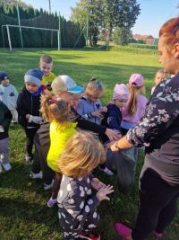 Przedszkolaki wrzucają śmieci do worka. (3)
