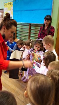 20. Pani Kasia rozdaje dzieciom prezenty.