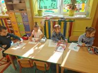 Dzieci pracują nad kolorowankami z postaciami z bajek