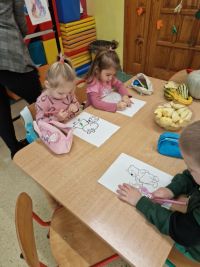 Dzieci koolorują prace z postaciami