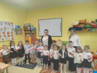 Dzieci z przedszkola z kotylionami i flagami