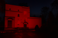 Budynek szkoły rozświetlony na czerwono.