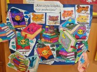 Tablica z czytelniczymi kolorowankami i cytatem Kto czyta książki, żyje podwójnie