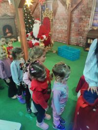 21. Dzieci odbierają prezenty z worka Mikołaja